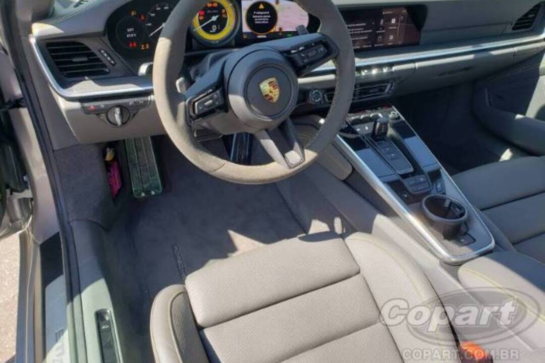 Interior sofisticado de um Porsche 911 Turbo S, com volante esportivo, painel digital e acabamento premium — símbolo do mercado de luxo automotivo