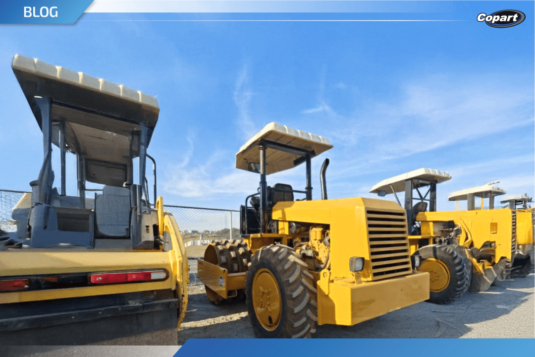 Máquinas amarelas de grande porte estacionadas em pátio, alinhadas para venda em leilão de pesados.