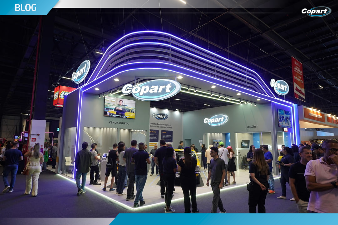Estande da Copart no Salão do Automóvel com grande fluxo de visitantes e iluminação em LED roxo.