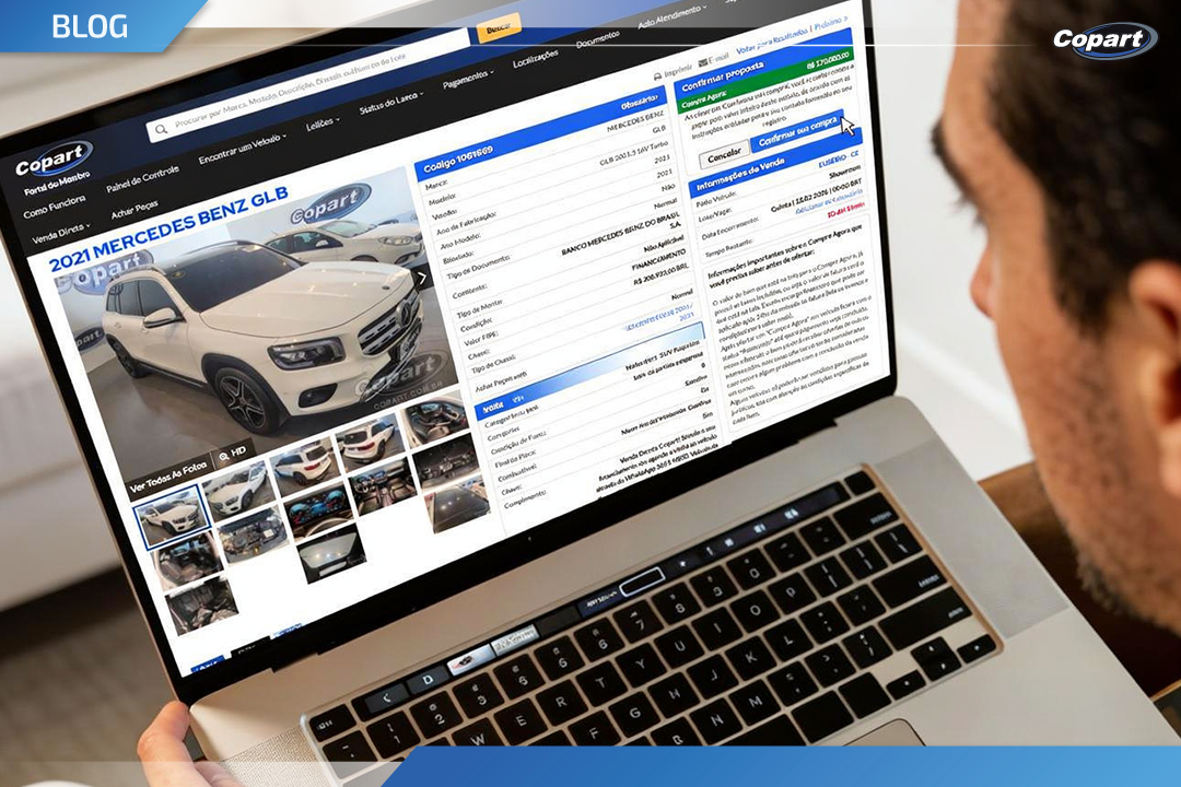 Homem navegando na plataforma da Copart em um notebook, visualizando a página de Venda Direta com anúncio de carro usado disponível para compra online.