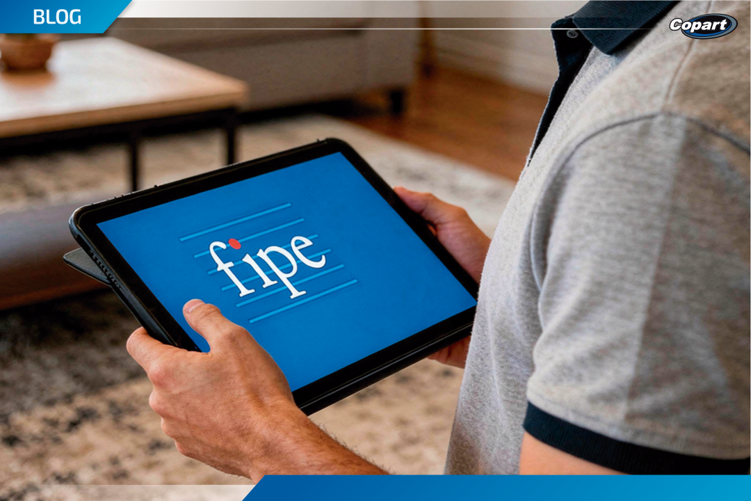 Pessoa segurando um tablet com a palavra “fipe” exibida na tela azul.